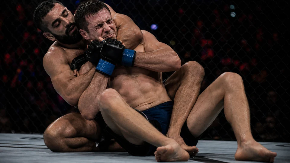 Anonymous MMA fighters in a cinematic submission grappling scramble near the cage